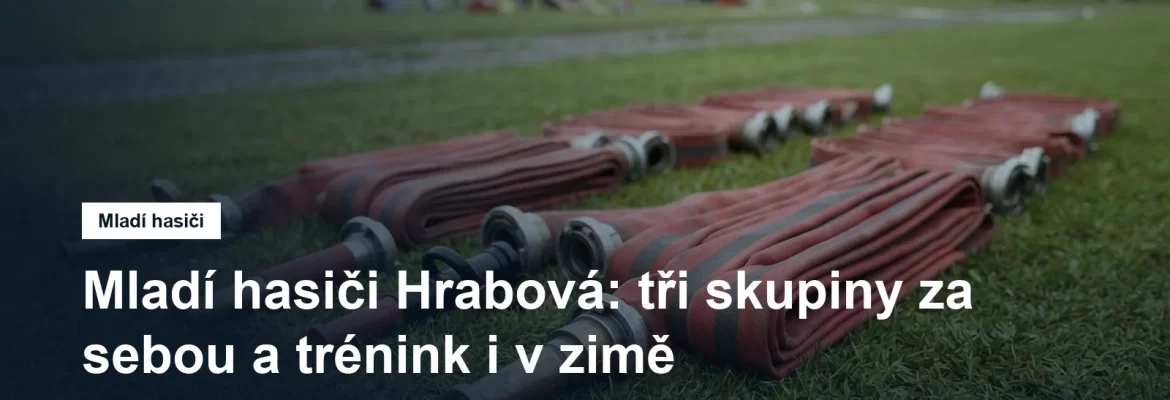 Hasičské proudnice a hadice srovnané na trávě