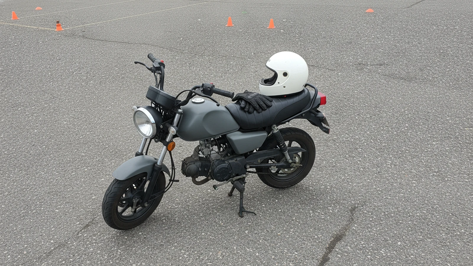 Přilba a rukavice na sedle cvičného motocyklu