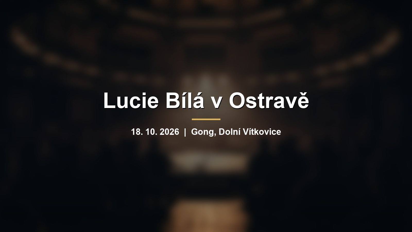 Rozmazaný koncertní sál s mikrofonem v teplém světle a nápisem Lucie Bílá v Ostravě