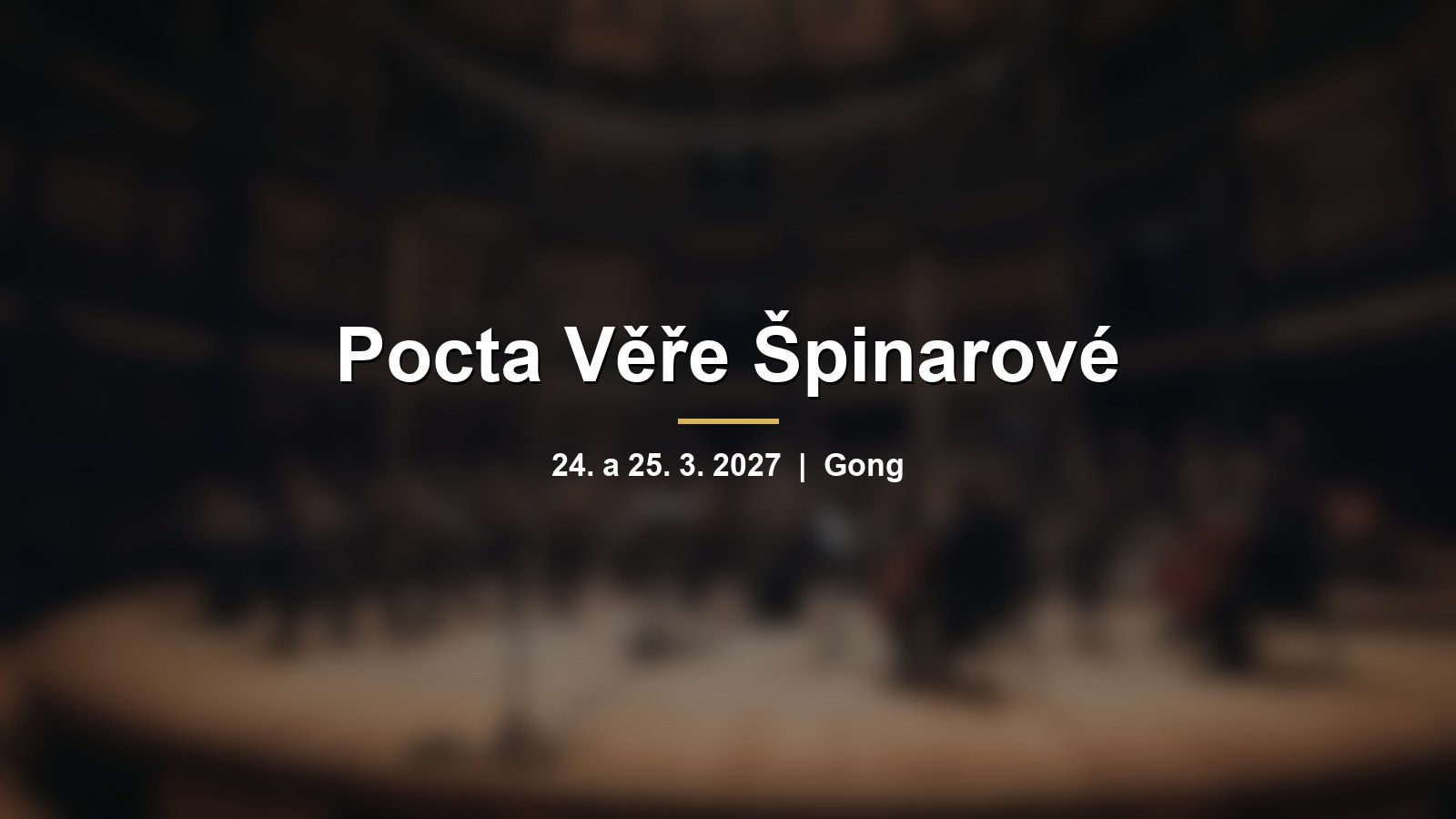 Rozmazaný orchestr na pódiu v kruhovém sále s nápisem Pocta Věře Špinarové