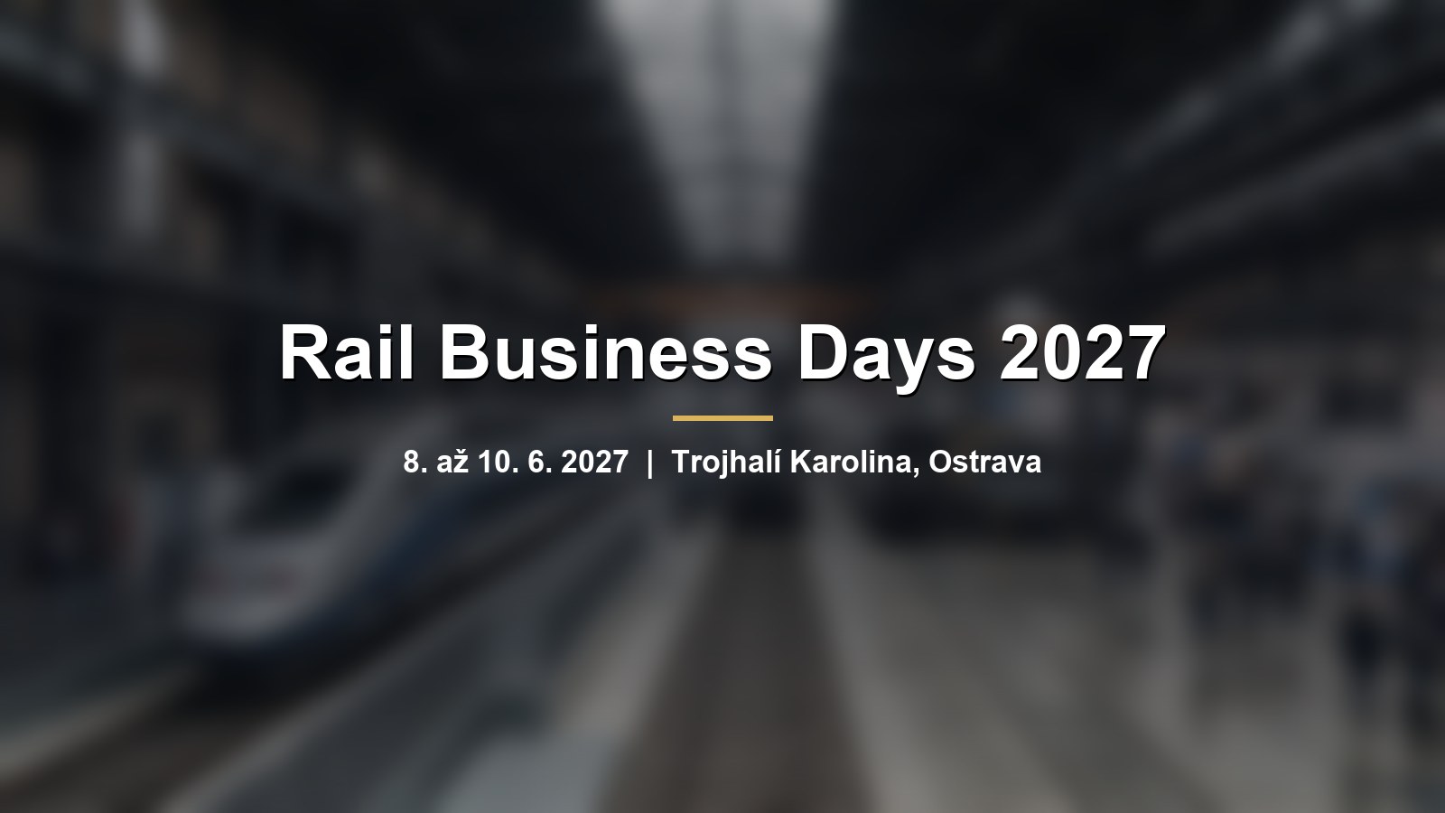 Rozmazaný moderní vlak v industriální hale s nápisem Rail Business Days 2027
